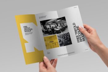 Free trifold brochure mockup held by two hands showing yellow and white inner panels with office photos on gray