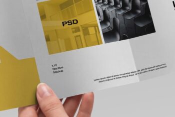 Free trifold brochure mockup close-up of a hand holding the panel with yellow image and brochure text detail