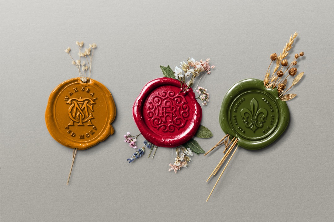 Botanical wax seal mockup showing three vintage wax stamps in mustard, burgundy and olive with dried botanicals on a gray background.