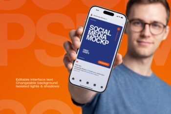 Hand holding Instagram post mockup on orange background, man in blue t-shirt presenting an iPhone social media post