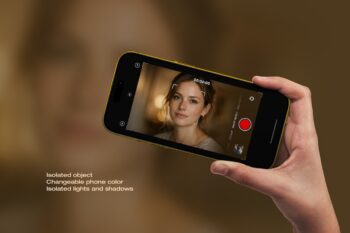 Hand holding iPhone video mockup in yellow phone color on a warm blurred background, recording a portrait on screen