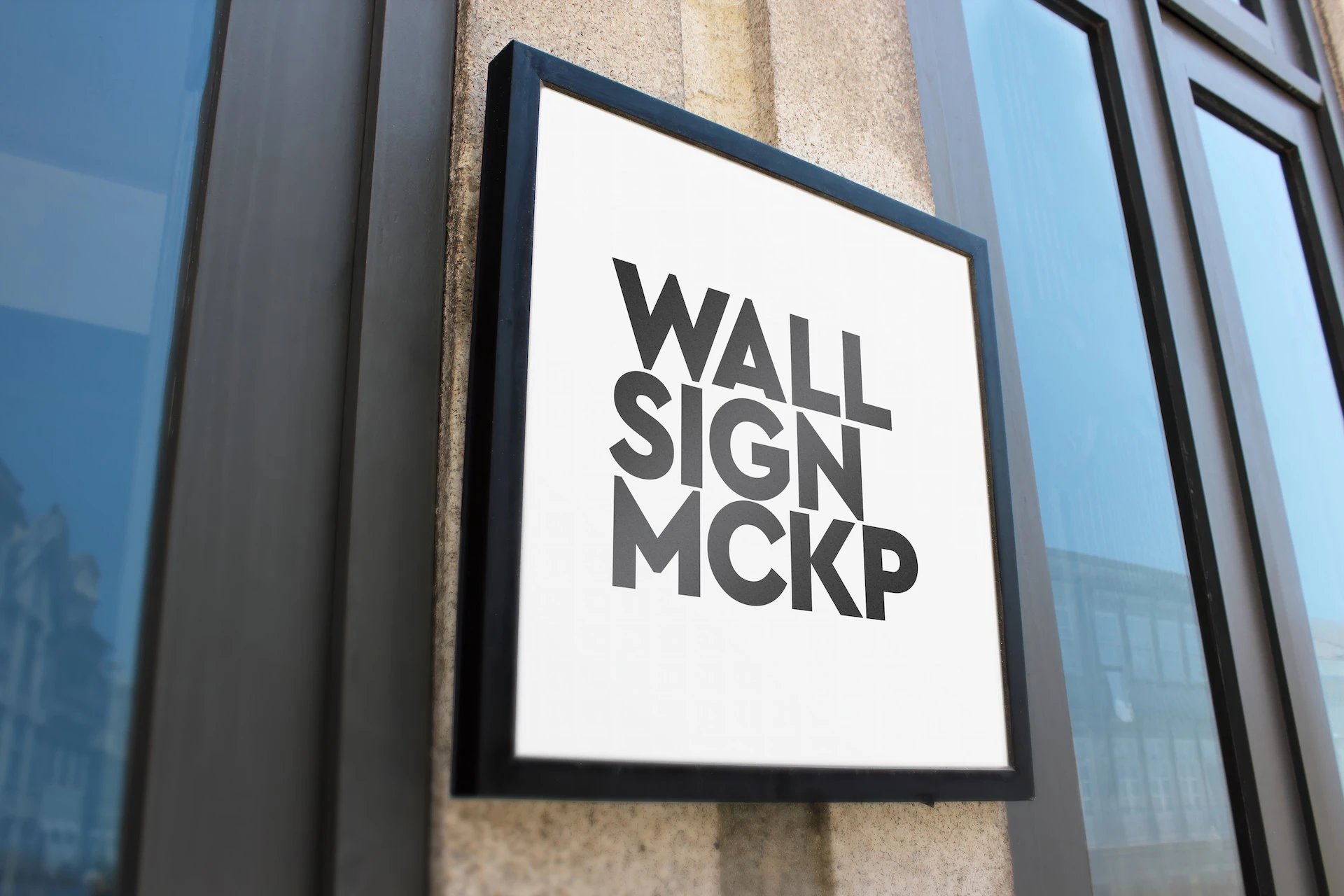Wall sign mockup set white framed sign mounted on a granite pillar between dark window frames, low angle view